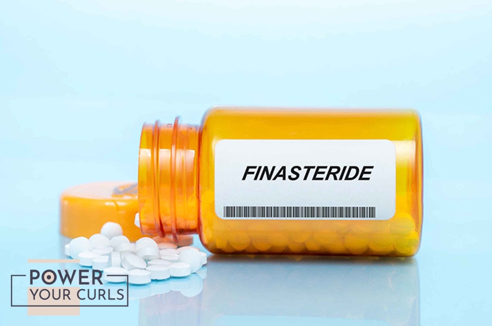 A bottle of finasteride that is tipped over. Its contents are spilled over a tabletop.