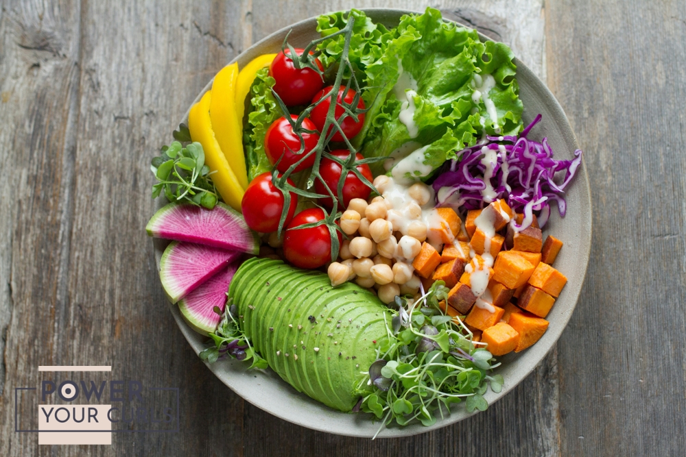 A photo of a healthy salad bowl containing various fruits and vegetables.