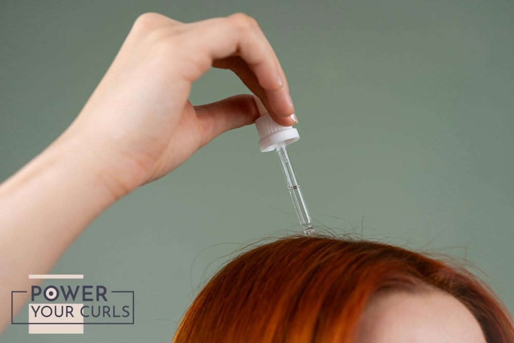 A woman applying minoxidil to her scalp via a dropper.