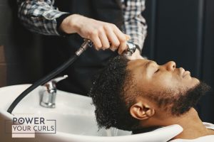 A man getting his hair washed at a salon.