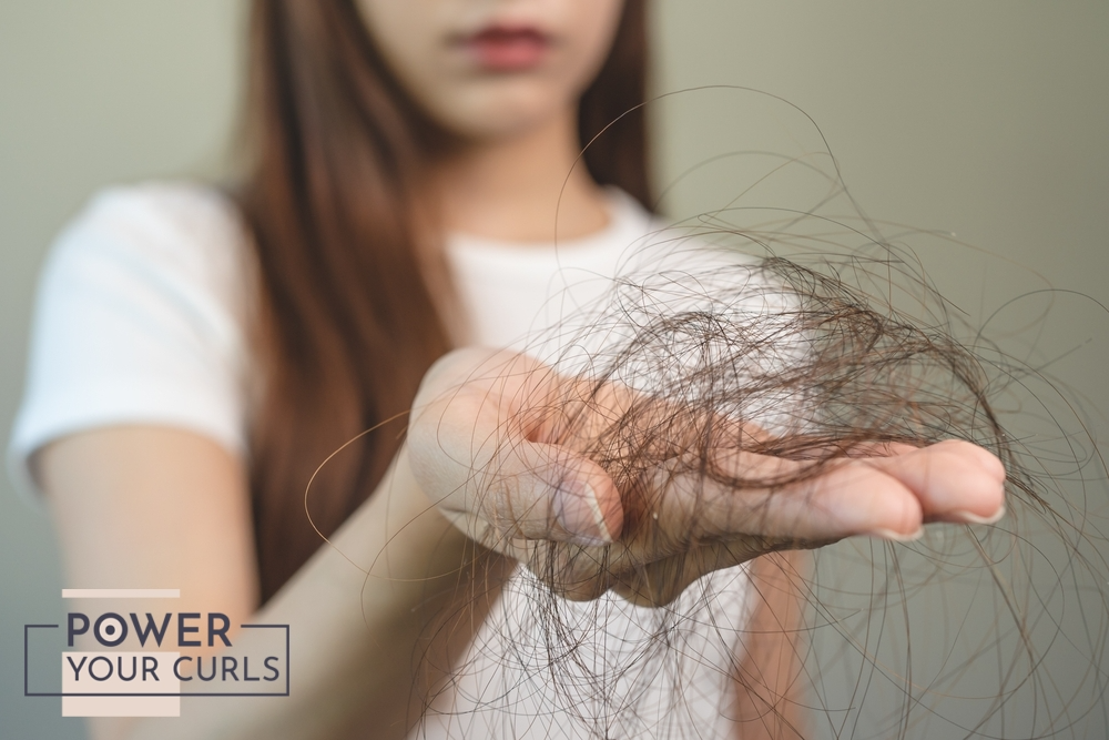 A girl holding a clump of damaged hair