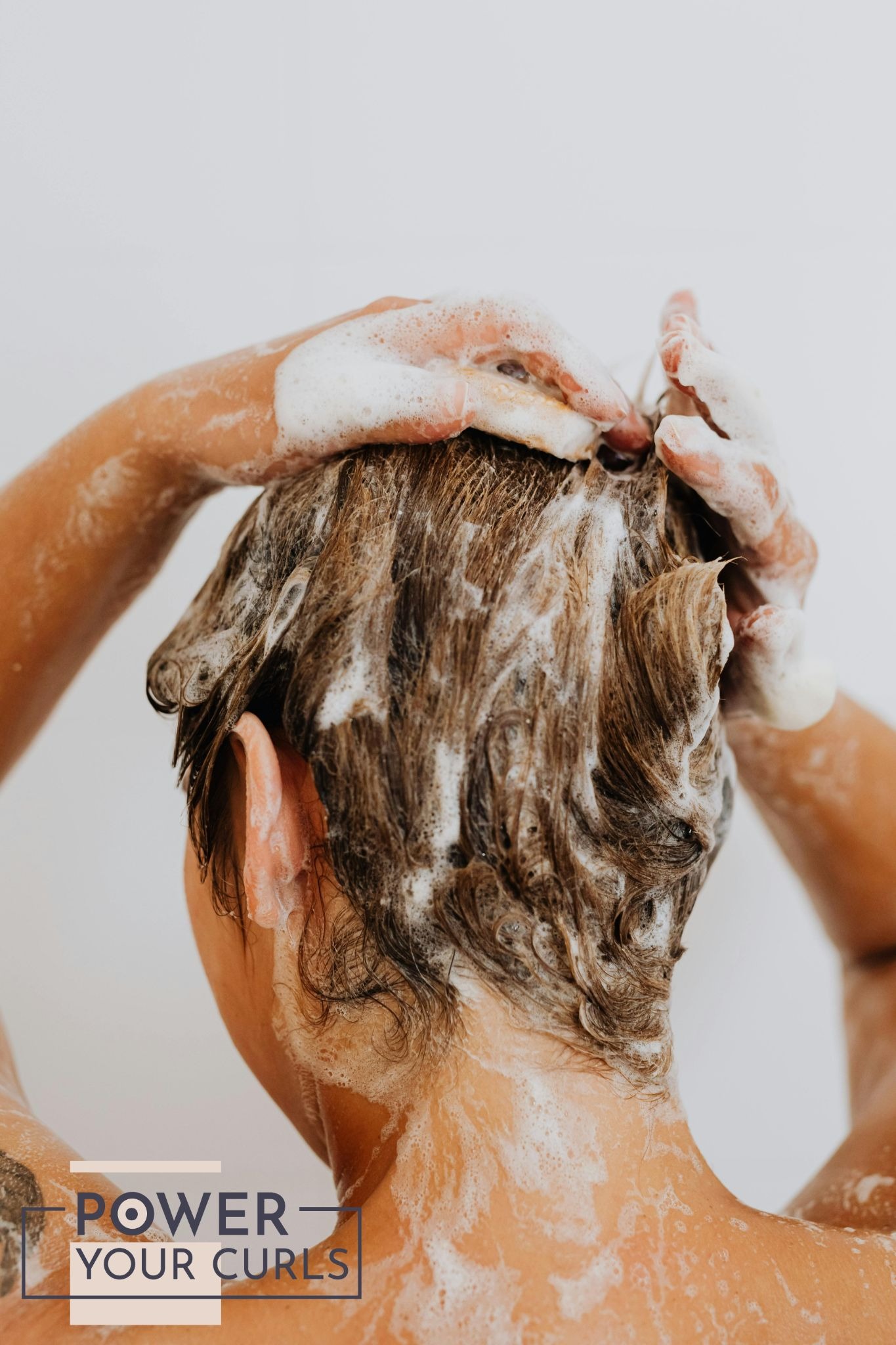 Parabens and Sulfates: Your Hair's Worst Enemy? 1 A photo of a woman, taken from behind, washing her hair with shampoo.