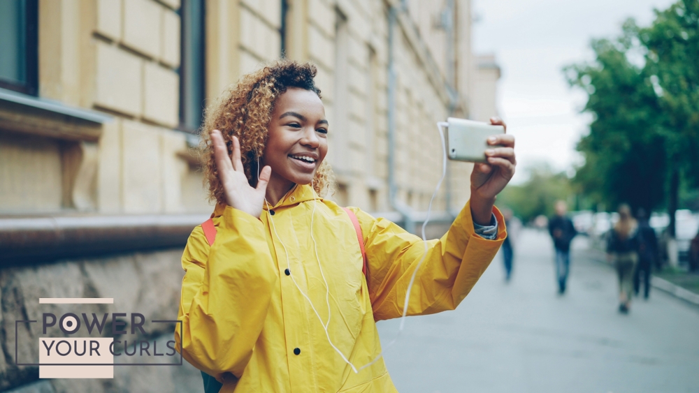 Woman taking a selfie with a smartphone outdoors.