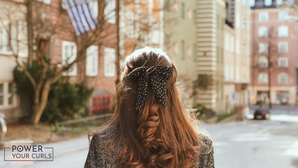 A woman with her back to the camera wearing a stylish hair bow.