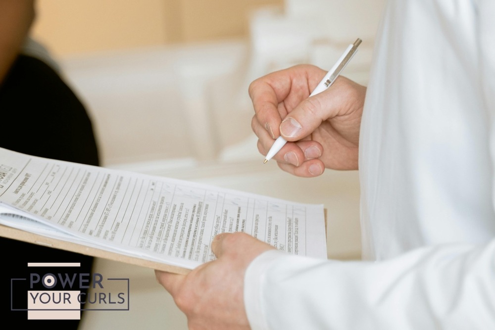 Six Effective Treatments For Hair Loss 3 A medical professional in a white coat examines a clipboard with patient documents.