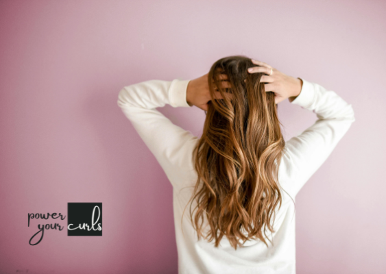 Curly Hair vs. Straight Hair Genetics: Everything You Need to Know 3 A woman facing away from the camera, showing of straight blonde hair.